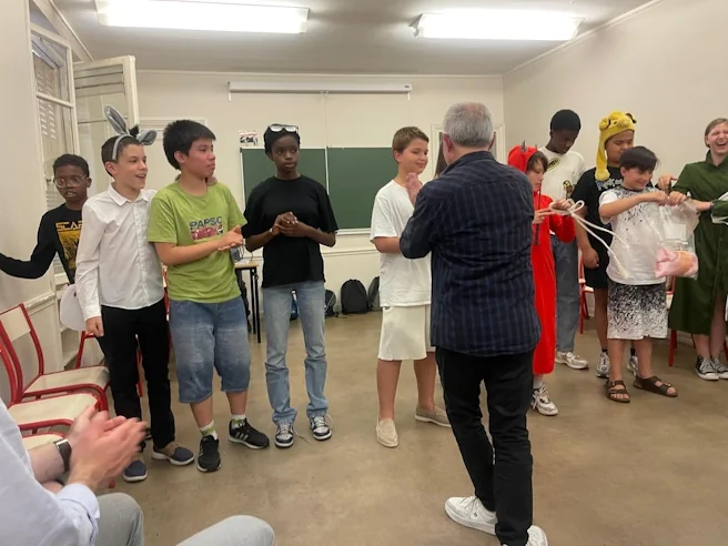 Des élèves costumés reçoivent des félicitations et des récompenses après leur pièce de théâtre.