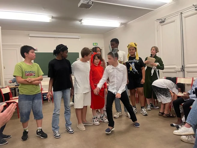 Groupe d’élèves en scène, costumés, après une pièce de théâtre jouée en anglais.