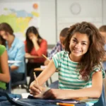 Lycéenne concentrée et épanouie en classe – Illustration d’un environnement serein et bienveillant typique des établissements scolaires hors contrat comme Ipécom Paris.