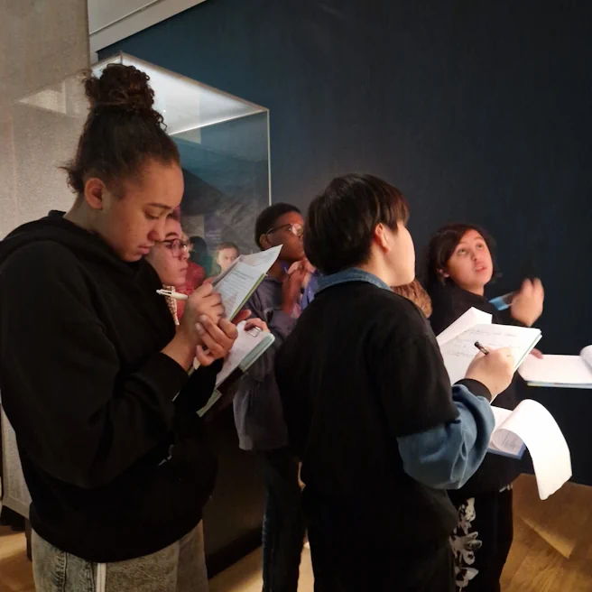 Élèves en train de prendre des notes devant une vitrine au Musée de l’Homme
