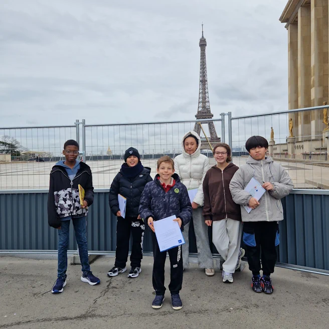 Élèves d’Ipécom Paris posant avec leurs carnets devant la Tour Eiffel, à proximité du Musée de l’Homme