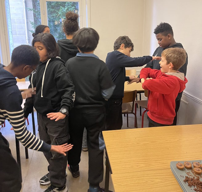 Collégiens du collège Ipécom Paris engagés dans une activité de groupe lors d’une séance pédagogique de Noël.